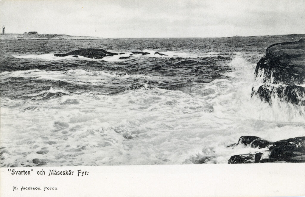 Svart-vitt foto av stormigt hav som slår mot klippa.