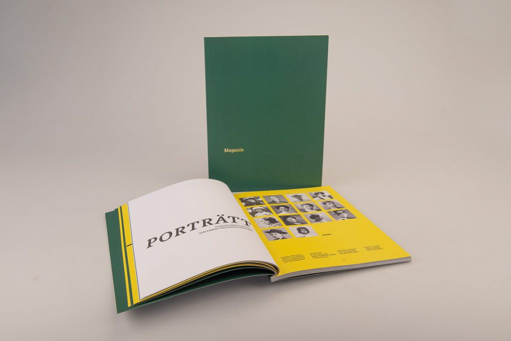 Foto. Ett magasin med grönt omslag med texten "magasin" i kursiva guldbokstäver samt ordet "mod" som är instansat i versaler.