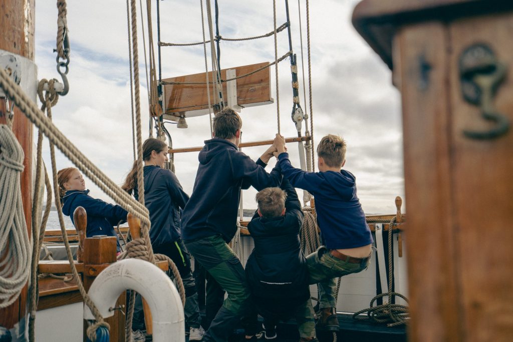 Foto. Fem barn ombord på ett fartyg.