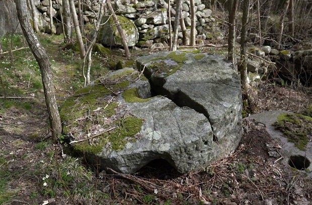 Färgfoto med en övergiven kvarnsten som har spruckit mitt itu.