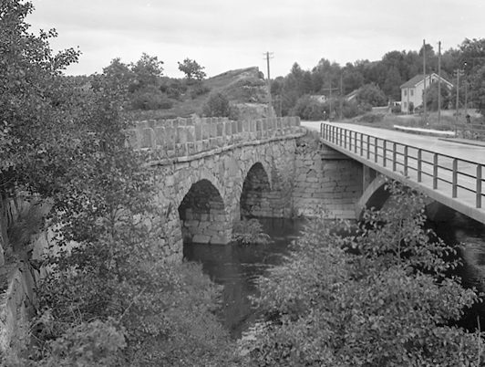 Svartvitt foto med två broar. Den äldre bron är murad med flera stenvalv.