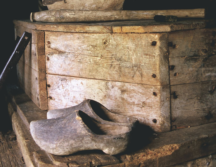 Färgfoto från kvarnens inre med träskor i förgrunden.