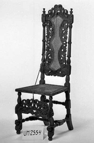 Foto av stol med flätad sits och hög ryggbricka i rotting.