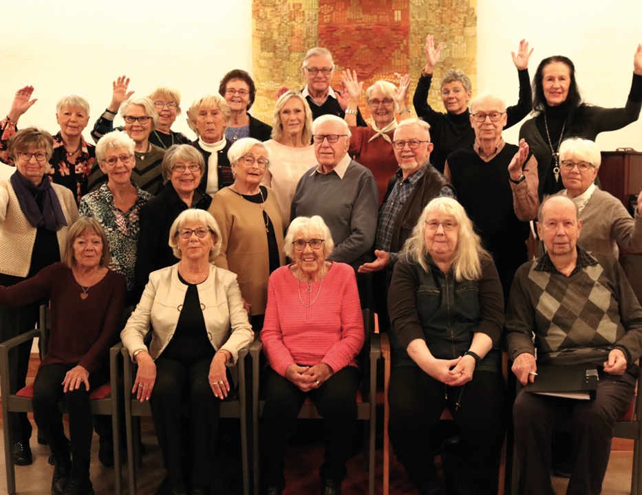 Gruppfoto. Vikenskör står uppställda och vinkar, ungefär 30 st seniorer.