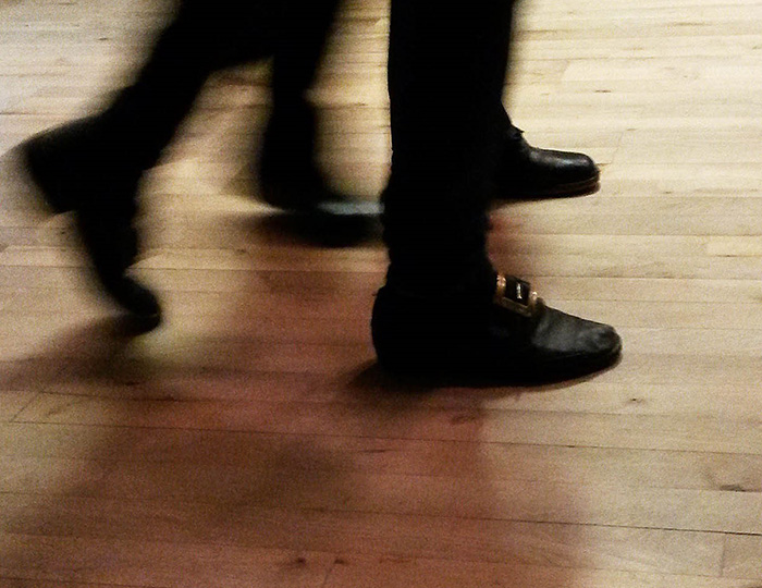 Bild på skor och ben på två personer som dansar på ett trägolv