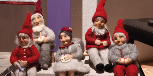 Foto. Fem detaljerade tomtefigurer av tvinnat garn placerade som om de poserade för ett ett familjefoto.