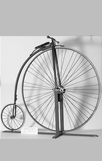Svartvitt föremålsfoto: Höghjulig - cykel med mycket stort framhjul.