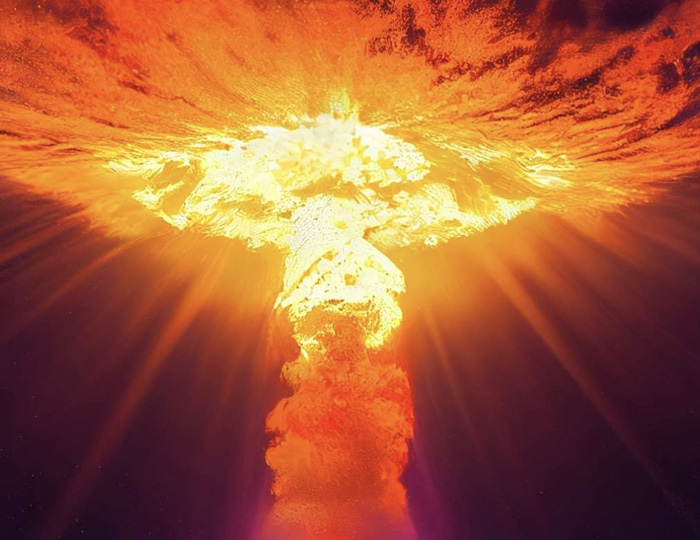 Foto. På kärnvapen bomb. Endast det svampformade rökmolnet i orange/rött mot himlen syns i bild.
