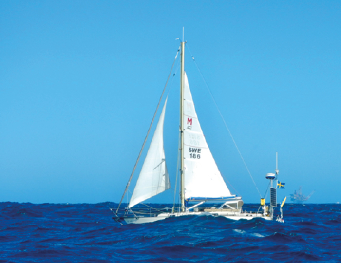 Foto. En segelbåt, Sirona III, en Monsun 31, på öppet hav med klarblå himmel.