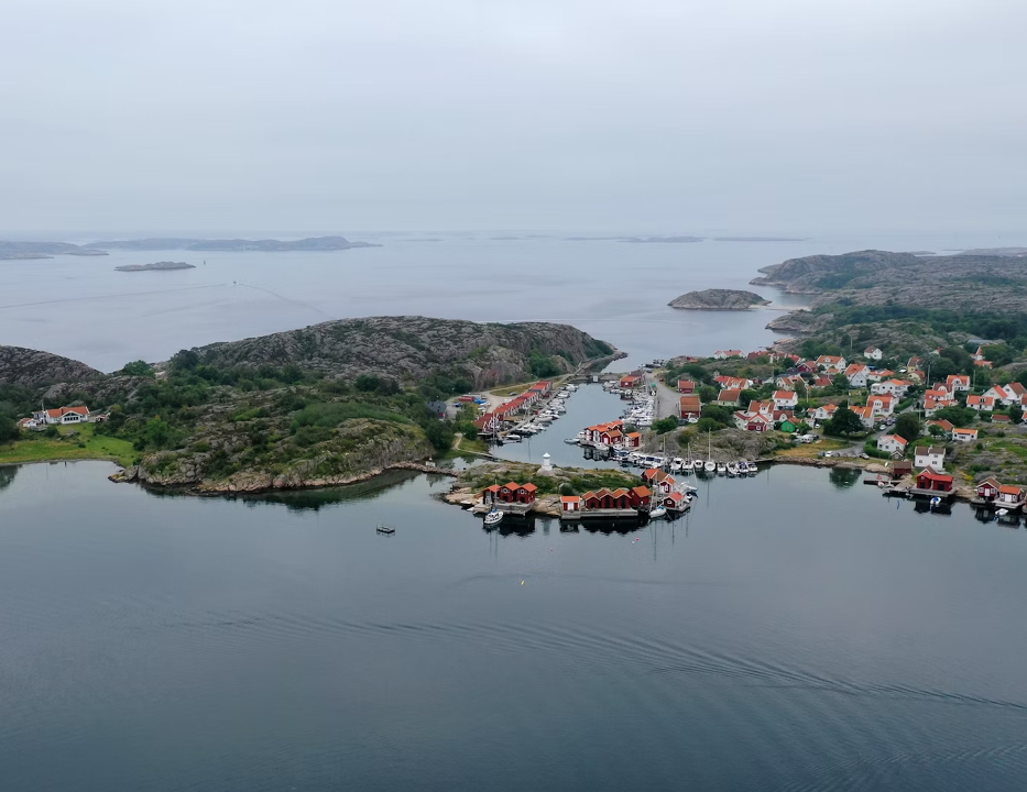 Foto. Bohus Malmön från ovan. Havet ligger stilla och det är disigt och grått i horisonten.