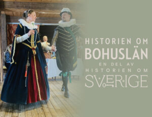 Foto. Kvinna och en man i renässanskläder dansar på trä golv