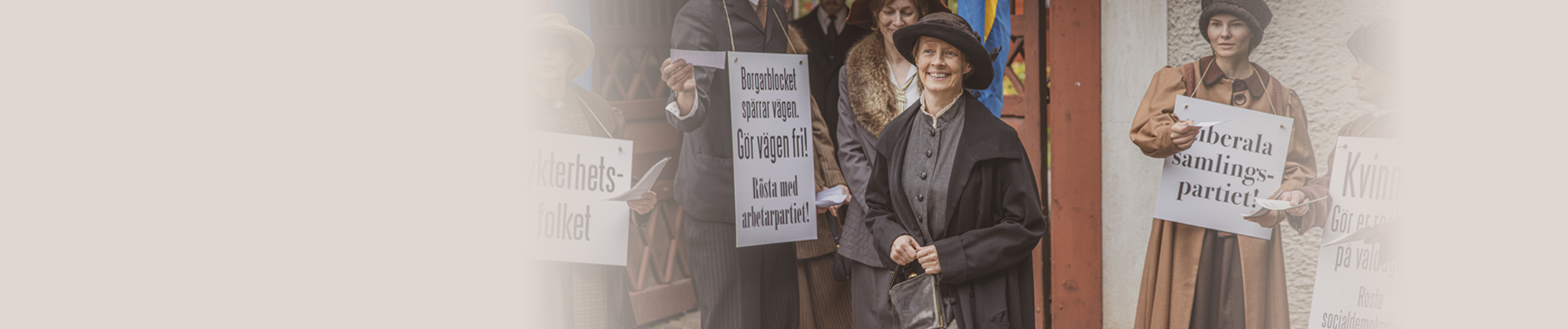 Foto. Kvinnor i hatt och med plakat som demonstrerar.